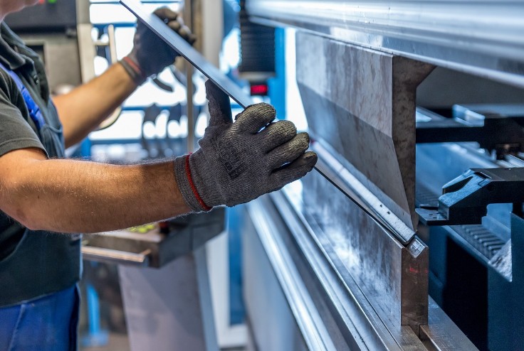 Arbeiter beim abkanten an einer Maschine